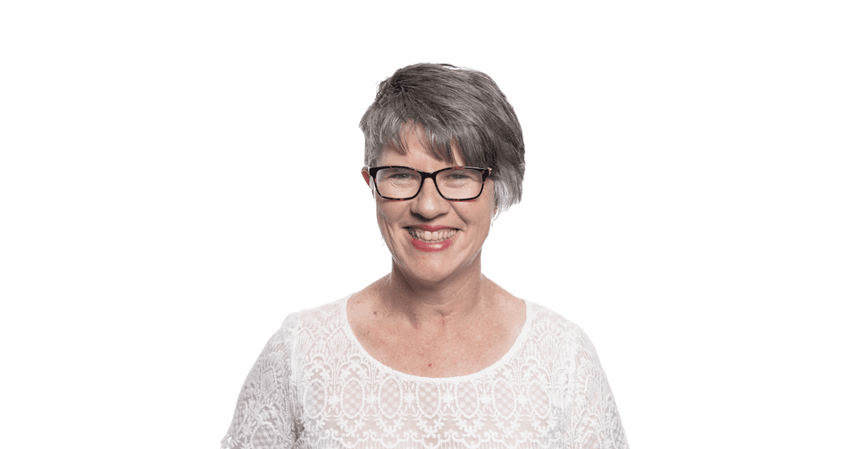 image of woman with grey hair smiling in white top