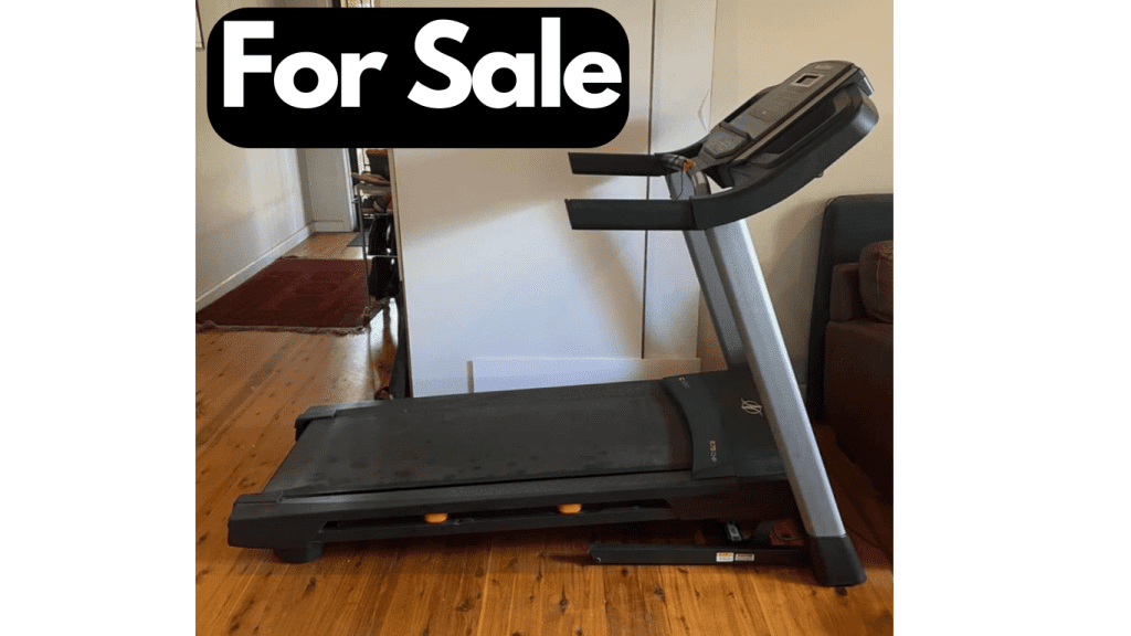 Image of Treadmill in living room with a For Sale sign
